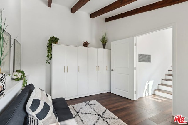 interior space featuring beam ceiling and dark hardwood / wood-style floors