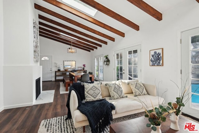 living room featuring dark hardwood / wood-style floors, french doors, vaulted ceiling with beams, and a notable chandelier