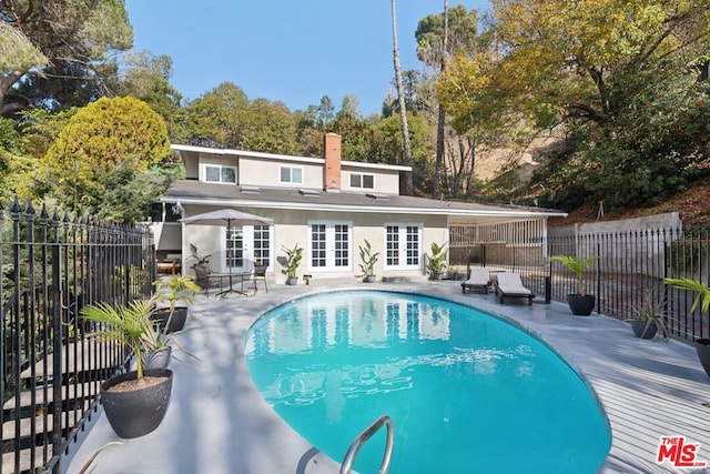 view of pool with french doors and a patio