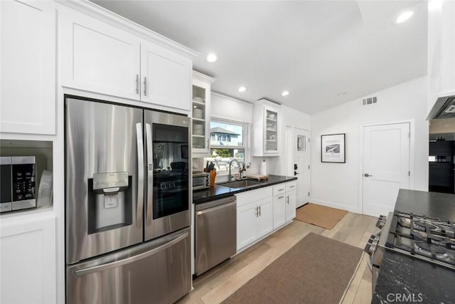 kitchen with white cabinetry, sink, stainless steel appliances, light hardwood / wood-style flooring, and lofted ceiling