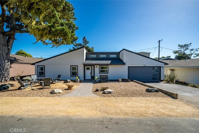 view of front facade with a garage and an outdoor fire pit