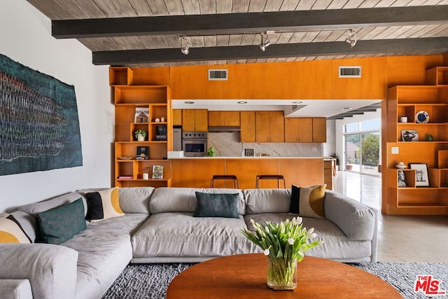 living room featuring beam ceiling and concrete floors