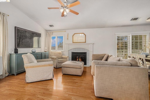 living room with ceiling fan, plenty of natural light, light hardwood / wood-style floors, and vaulted ceiling