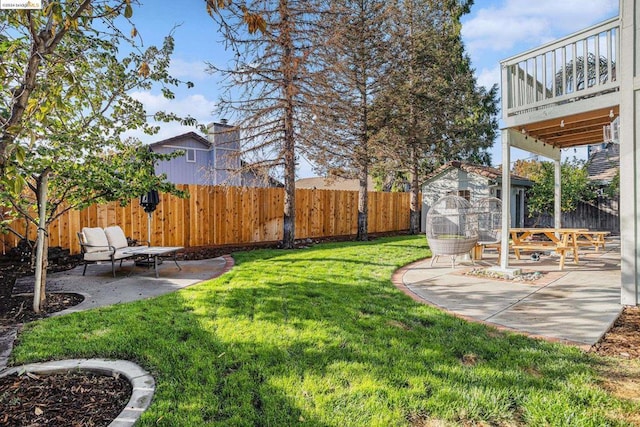 view of yard featuring a wooden deck, a patio, and a storage shed