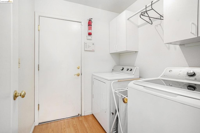 laundry area with cabinets, independent washer and dryer, and light hardwood / wood-style flooring