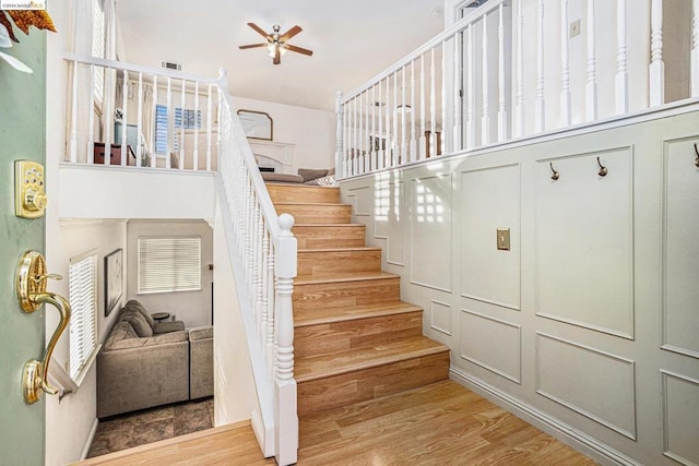 stairs with ceiling fan and wood-type flooring