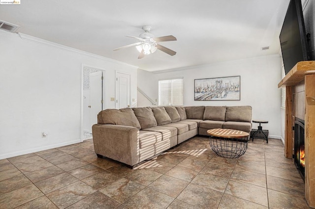 living room featuring ceiling fan, dark tile patterned floors, and ornamental molding