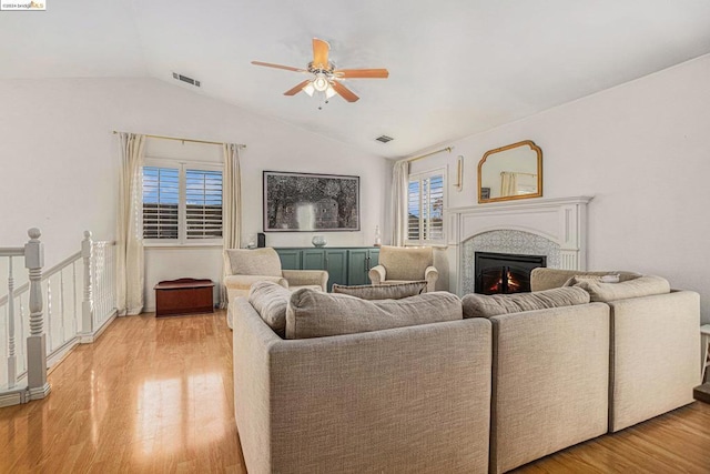 living room featuring light hardwood / wood-style floors, vaulted ceiling, and ceiling fan