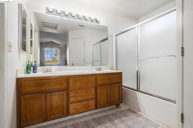 bathroom with tile patterned floors, vanity, and bath / shower combo with glass door