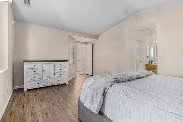 bedroom with light hardwood / wood-style floors and vaulted ceiling