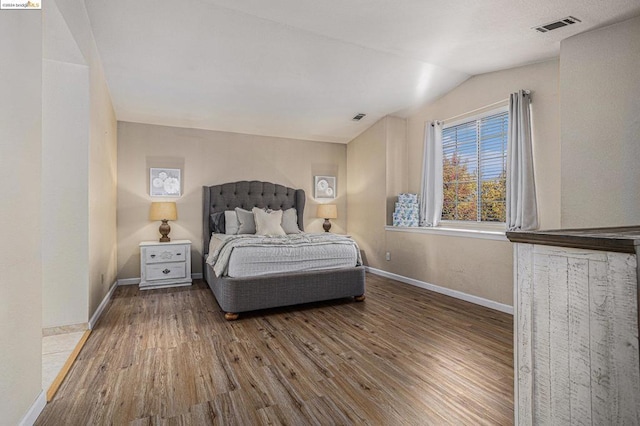 bedroom with hardwood / wood-style floors and vaulted ceiling