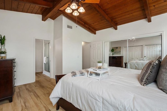 bedroom with two closets, wooden ceiling, ceiling fan, light wood-type flooring, and beam ceiling