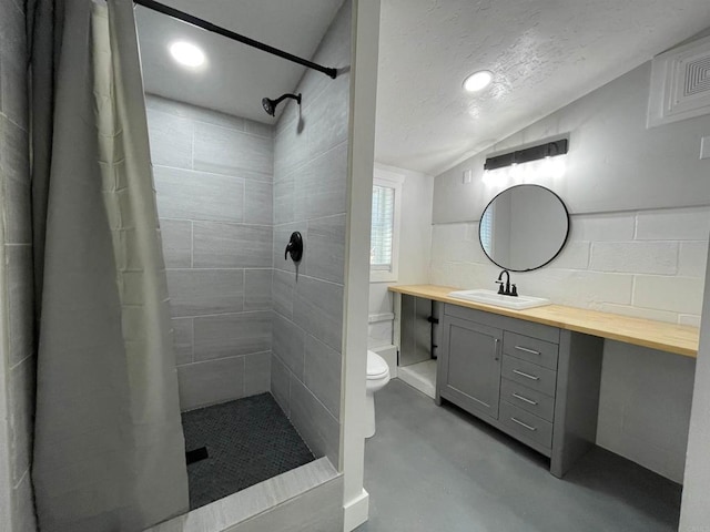 bathroom with a textured ceiling, vanity, concrete floors, toilet, and walk in shower