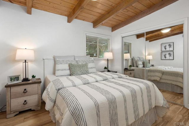 bedroom with light hardwood / wood-style floors, a closet, wood ceiling, and vaulted ceiling with beams