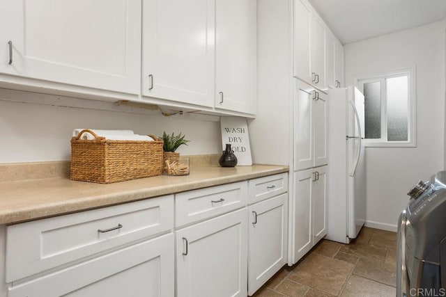 clothes washing area featuring cabinets and independent washer and dryer