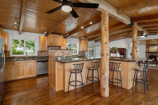 kitchen with a kitchen breakfast bar, dark wood-type flooring, stainless steel appliances, and backsplash