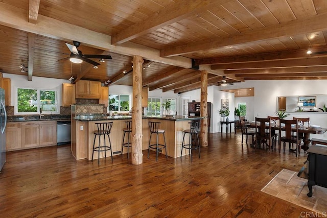 kitchen with wood ceiling, a kitchen bar, a wood stove, tasteful backsplash, and vaulted ceiling with beams