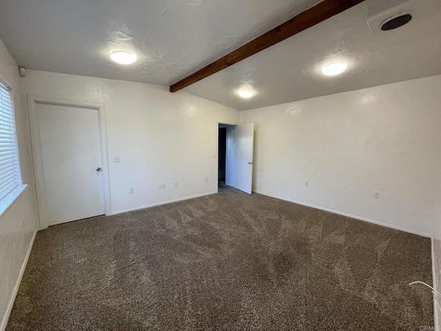 carpeted empty room featuring lofted ceiling with beams