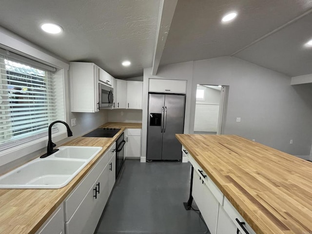 kitchen featuring white cabinetry, wooden counters, lofted ceiling, black appliances, and sink