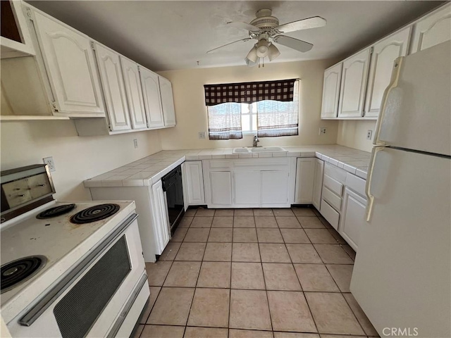 kitchen with white cabinets, tile counters, light tile patterned flooring, and white appliances