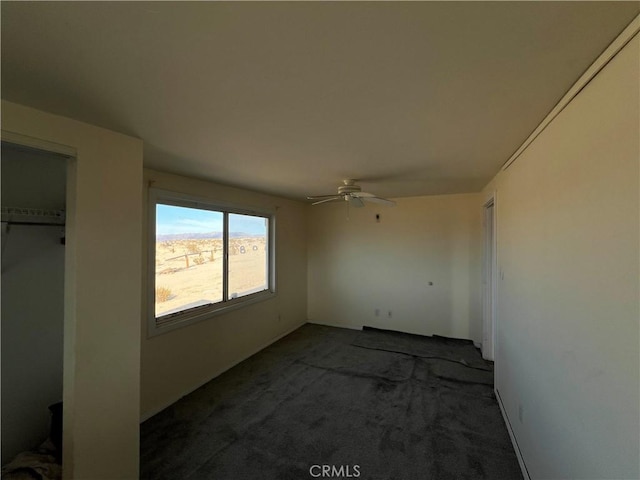 unfurnished bedroom featuring dark colored carpet and ceiling fan