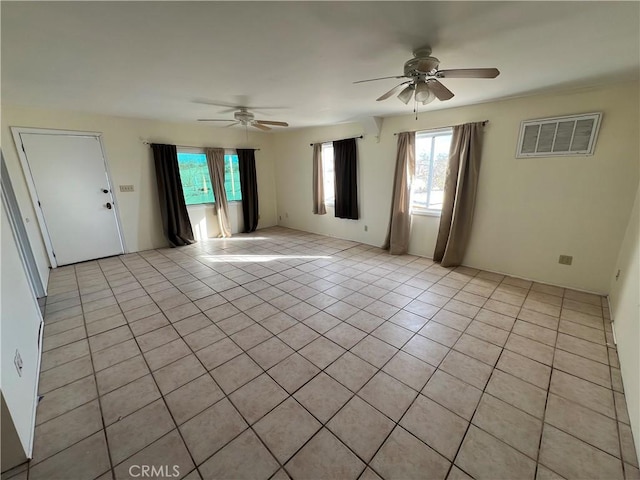 empty room with an AC wall unit, ceiling fan, and light tile patterned flooring