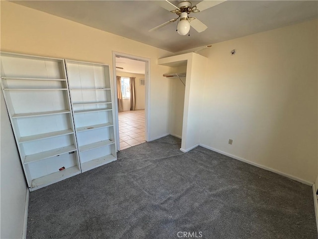 unfurnished bedroom with ceiling fan, a closet, and dark colored carpet