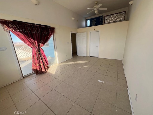 empty room with ceiling fan, light tile patterned flooring, and high vaulted ceiling