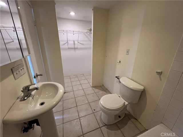 bathroom featuring toilet, tile patterned floors, and sink