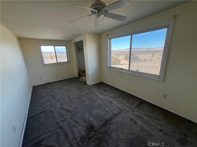 carpeted spare room with ceiling fan