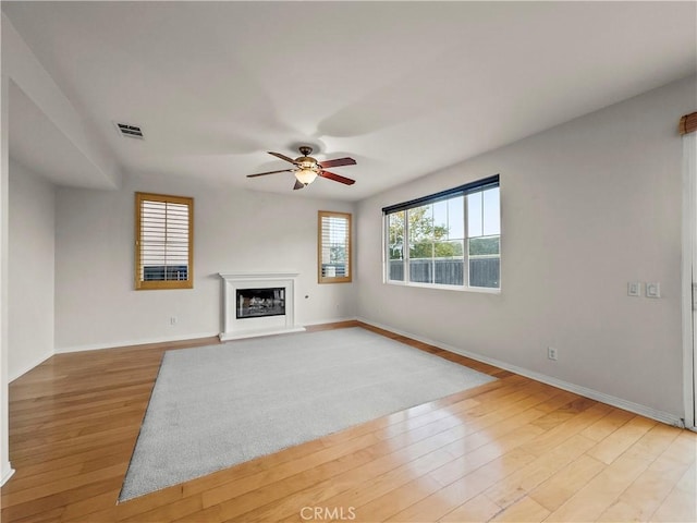 unfurnished living room featuring ceiling fan and light hardwood / wood-style flooring