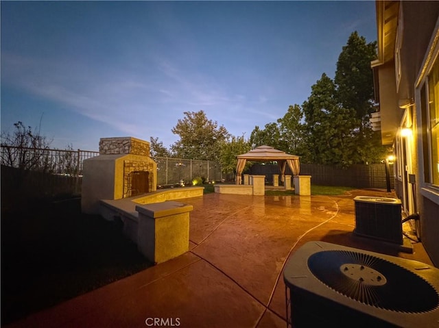 exterior space featuring a gazebo, an outdoor fireplace, a patio, and central AC