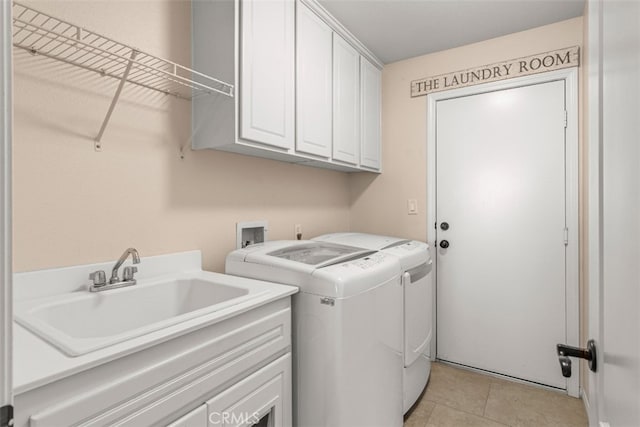 clothes washing area featuring cabinets, light tile patterned floors, sink, and washing machine and clothes dryer