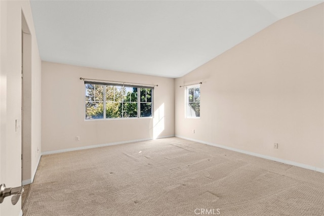 unfurnished room featuring light colored carpet and vaulted ceiling