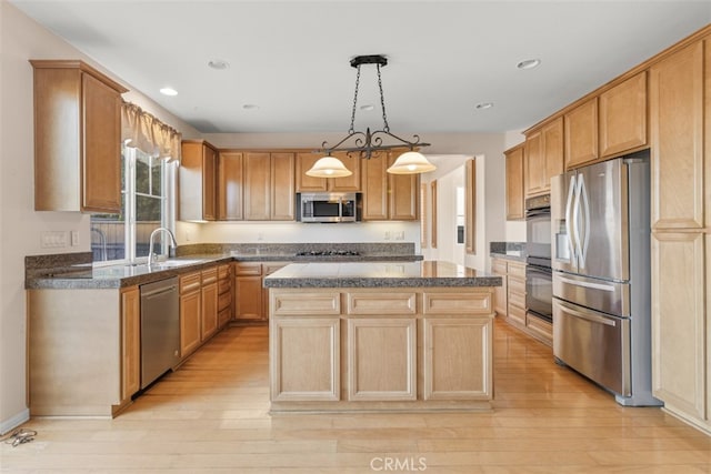 kitchen with pendant lighting, a center island, light wood-type flooring, and stainless steel appliances