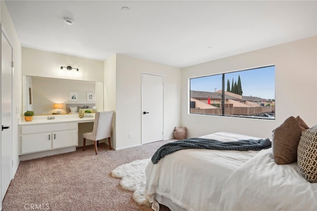 bedroom featuring built in desk and light carpet