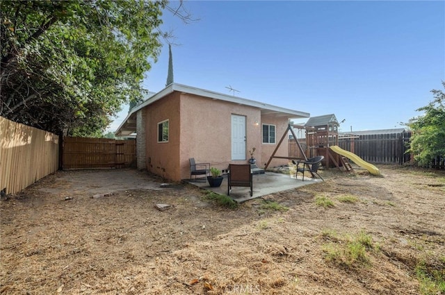 rear view of house with a patio and a playground