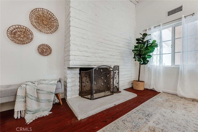 living room featuring a brick fireplace and hardwood / wood-style floors