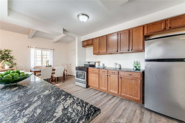 kitchen featuring light hardwood / wood-style floors, dark stone countertops, beam ceiling, and stainless steel appliances