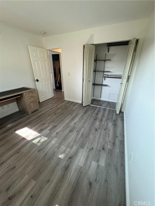 unfurnished bedroom with a closet and hardwood / wood-style floors