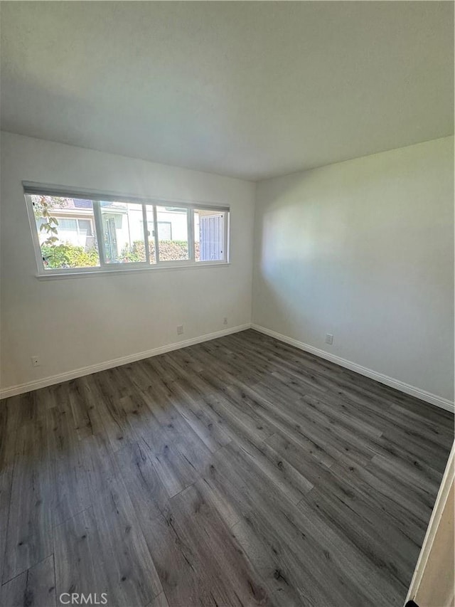 spare room featuring dark wood-type flooring