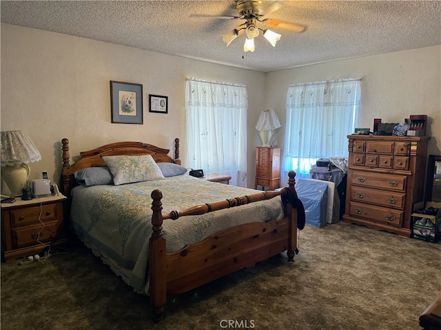 carpeted bedroom featuring ceiling fan and a textured ceiling