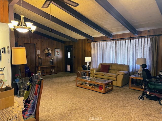 carpeted living room with a notable chandelier, vaulted ceiling with beams, and wood walls