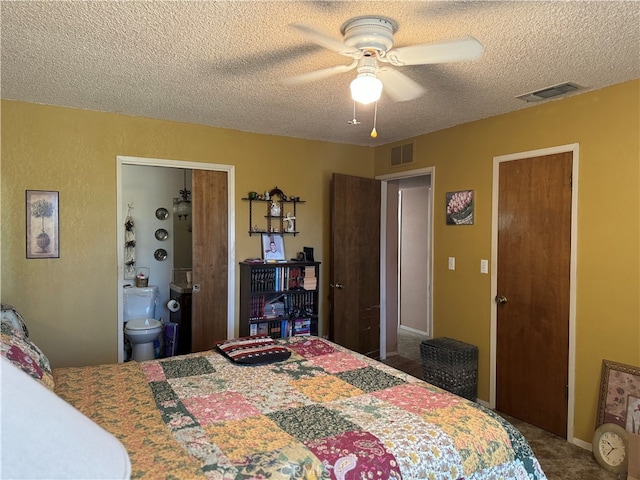 bedroom featuring a textured ceiling, ensuite bath, carpet, and ceiling fan