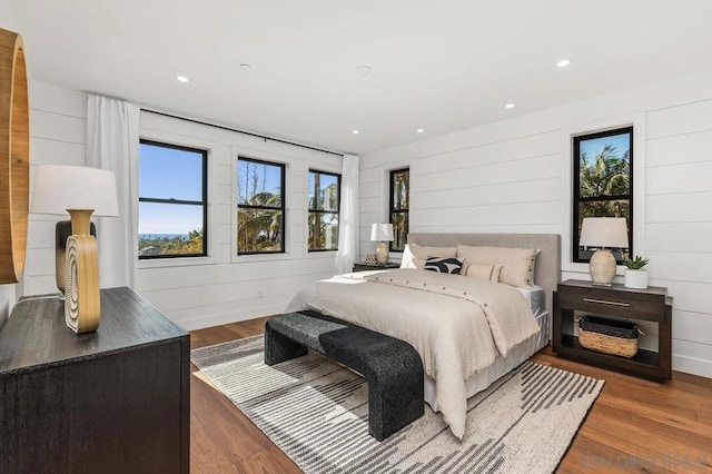 bedroom featuring dark hardwood / wood-style floors and wood walls