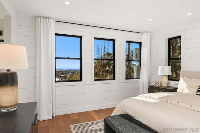 bedroom featuring hardwood / wood-style floors and wooden walls