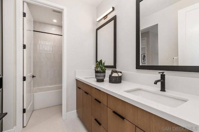 bathroom with tile patterned floors, vanity, and tiled shower / bath