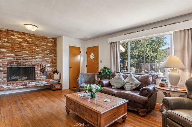 living room featuring hardwood / wood-style floors and a brick fireplace