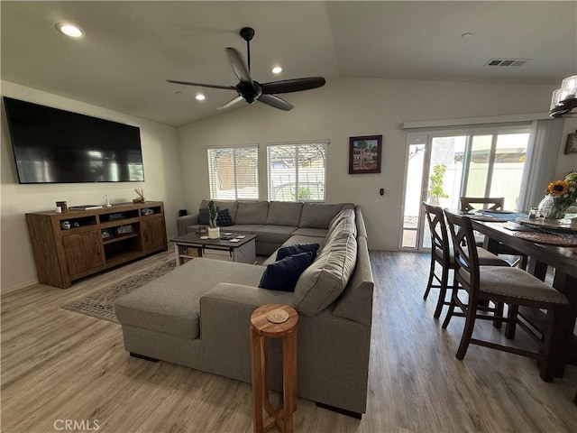 living room featuring light hardwood / wood-style flooring, a wealth of natural light, lofted ceiling, and ceiling fan