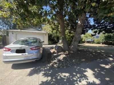 view of property hidden behind natural elements featuring a garage